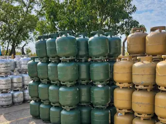 Pilhas de botijões P13 verdes da Copagaz, amarelos da Supergasbras e prata da Nacional Gás no pátio